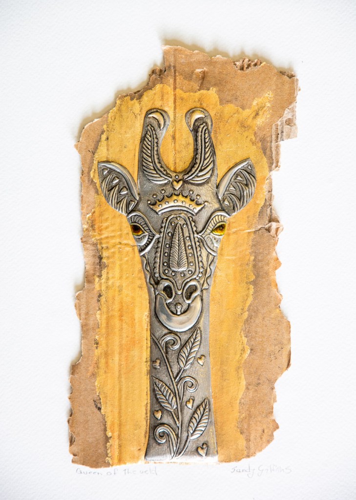 Hand-embossed pewter Giraffe with gold leaf set on a recycled packing box in a white box frame by Sandy Griffiths.