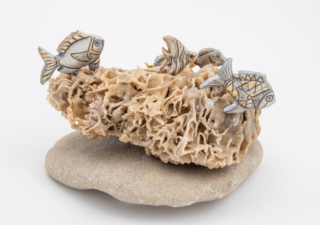 Hand-embossed pewter fish sculpture by Sandy Griffiths, featuring five intricately detailed embossed fish mounted on a natural coral and rock base, strengthened with resin.