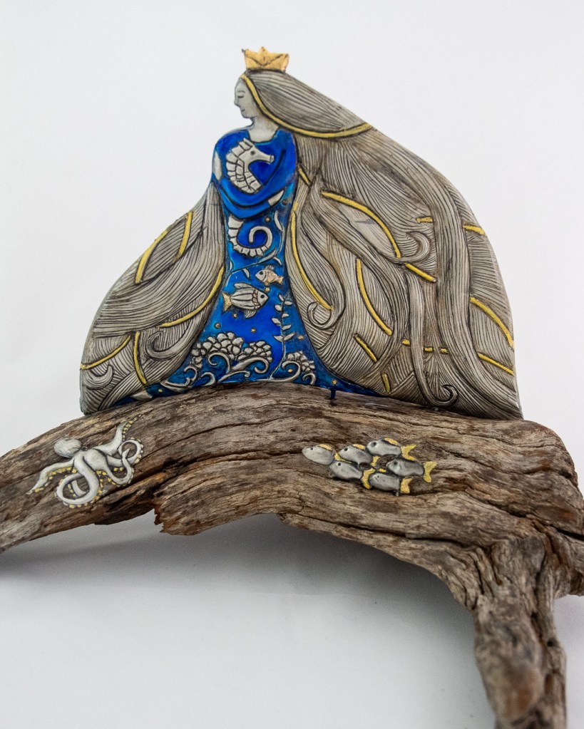 She carries the ocean in her hair. Hand-embossed pewter and clay set on driftwood. Size 320mm x 190mm x 230mm high.